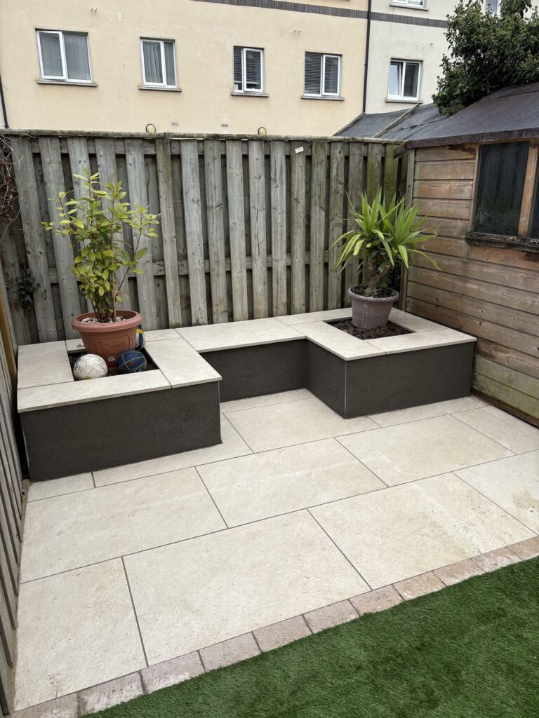 Stylish patio area in Wicklow with stone tiles, planters, and a wooden fence, creating a cozy outdoor space