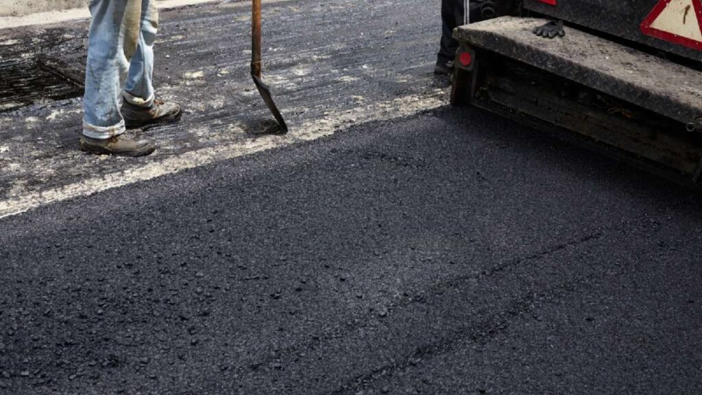 Workers laying fresh asphalt on a driveway, with tools and machinery visible, showcasing Driveways Wicklow services