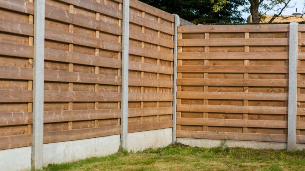 Wooden fence panels with concrete posts, enclosing a grassy area, showcasing a clean and modern design for Driveways Wicklow
