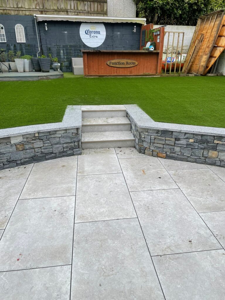 Stone steps lead to a grassy area with a wooden bar labeled "Function Room" in a patio setting in Wicklow