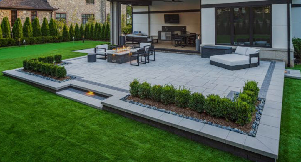Stylish patio with sandstone paving, fire pit, seating area, and landscaped greenery in a modern outdoor setting in Wicklow