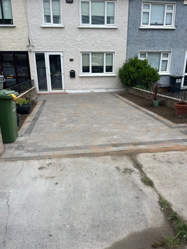 Newly paved driveway with patterned stones, adjacent to a house, featuring a green bin and potted plants in Wicklow