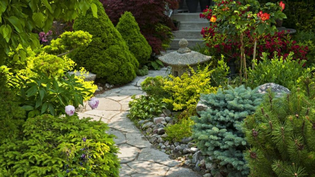 Lush garden path with vibrant flowers, shrubs, and a stone lantern, showcasing beautiful landscaping in Wicklow